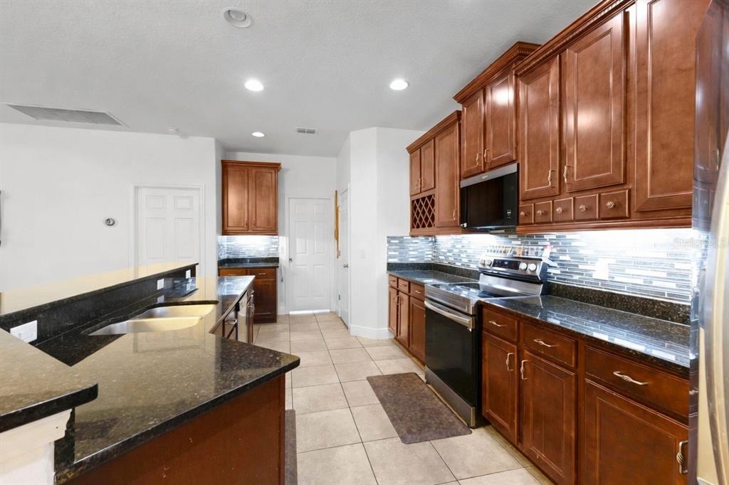 A spacious room with light-colored walls, tile flooring, a tray ceiling, and a sliding glass door — 3950 SUNSET LAKE DRIVE, LAKELAND, FL