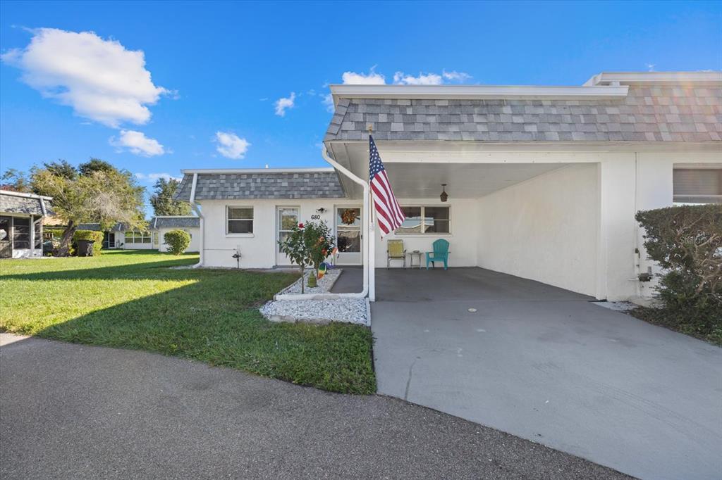A sunroom features light green walls, two armchairs, a side table, and a ceiling fan — 680 CIRCLEWOOD DRIVE UNIT W3, VENICE, FL