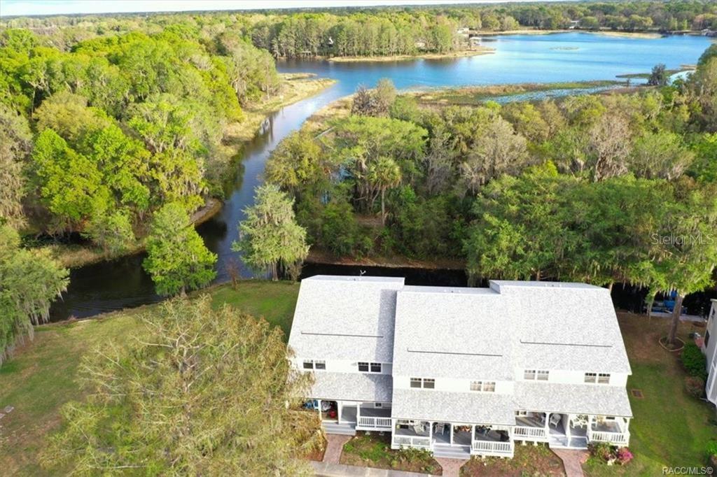 An aerial view of a multi-story house situated next to a narrow river and lake — 1340 CYPRESS COVE COURT, INVERNESS, FL
