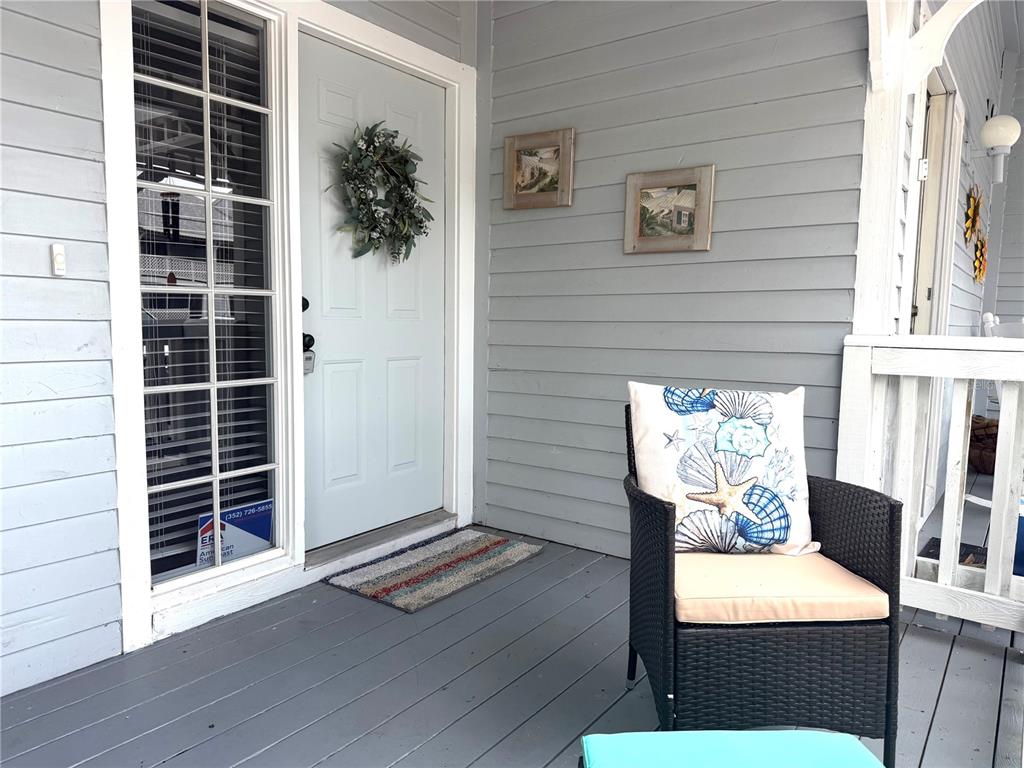 A front porch features gray siding, a light blue door with a wreath, and wicker seating — 1340 CYPRESS COVE COURT, INVERNESS, FL