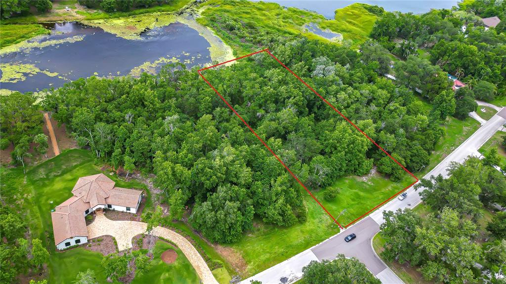 An aerial view shows a wooded residential lot outlined in red next to a house — LAKE HILLS DRIVE, RIVERVIEW, FL