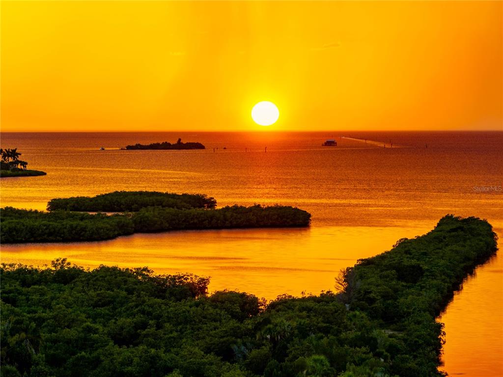 A vibrant sunset over a calm body of water with several small, mangrove-covered islands — 8727 BETTY STREET, PORT RICHEY, FL