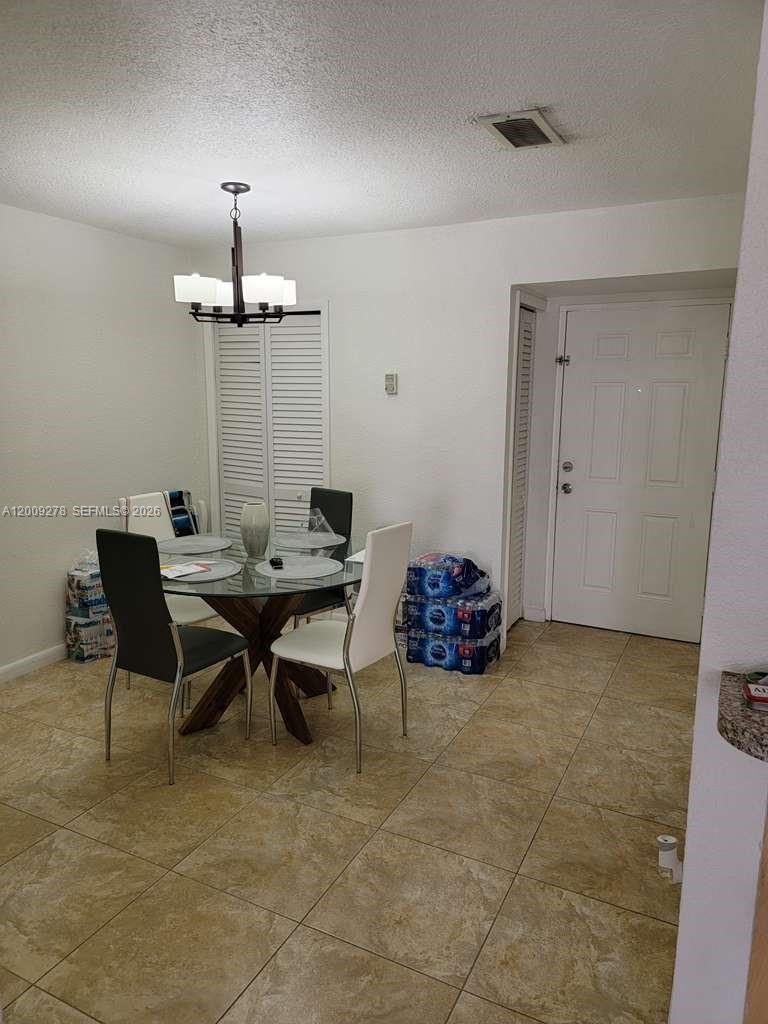 A dining area features a glass-topped table, four chairs, and tile flooring — 8425 NW 8th St # 306, Miami FL 33126, MIAMI, FL