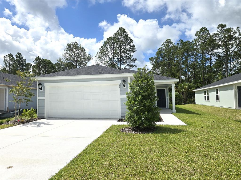 A light blue single-story house with a two-car garage and a front walkway — 11 DILLY COURT, PALM COAST, FL