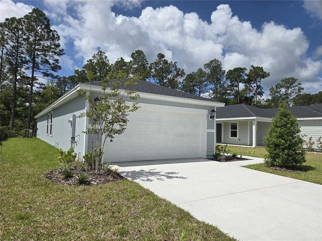 A light blue single-story house with a two-car garage and a concrete driveway — 11 DILLY COURT, PALM COAST, FL