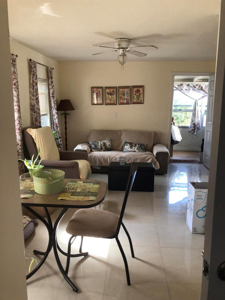 A living room with a dining table, sofa, and tile flooring leads to a patio — 1021 SW 5th Street, Miami FL 33130, MIAMI, FL