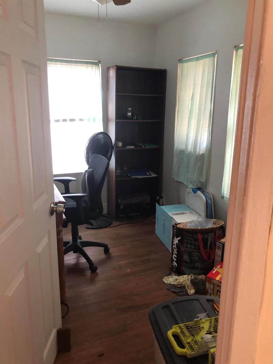 A small home office features wood-look flooring, a dark bookshelf, and a desk with a chair — 1021 SW 5th Street, Miami FL 33130, MIAMI, FL