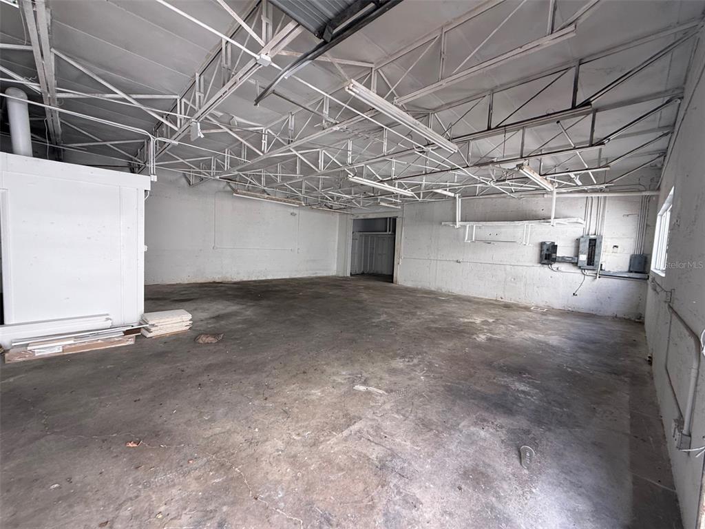 An empty industrial warehouse space features exposed metal trusses, concrete floors, and white walls — 14020 NW 19TH AVENUE, OPA LOCKA, FL