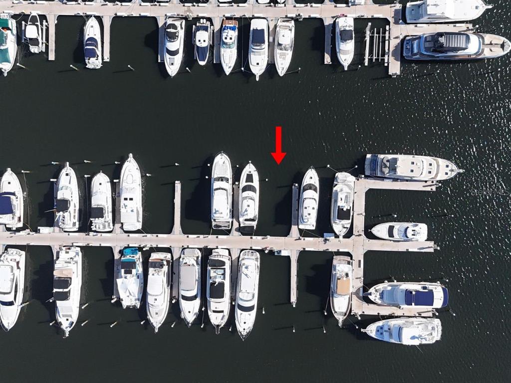 An aerial view of a marina with numerous boats docked in slips along wooden piers — 102 RIVIERA DUNES WAY UNIT C-24, PALMETTO, FL