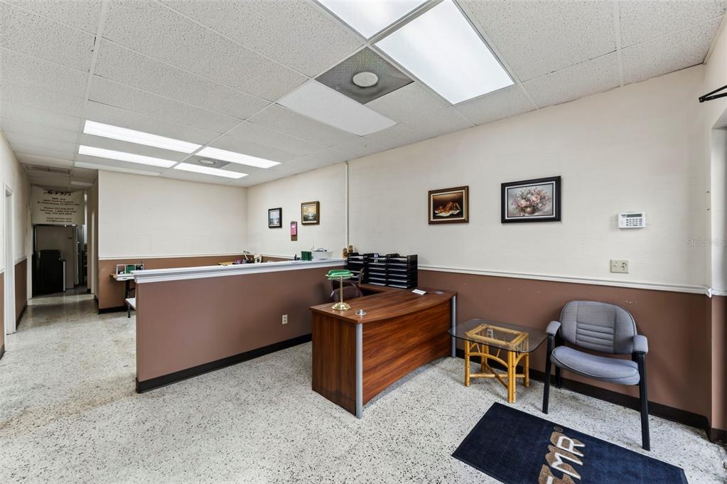 An office reception area features a wooden desk, a gray chair, and a half-wall partition — 3632 CENTRAL AVENUE, ST PETERSBURG, FL