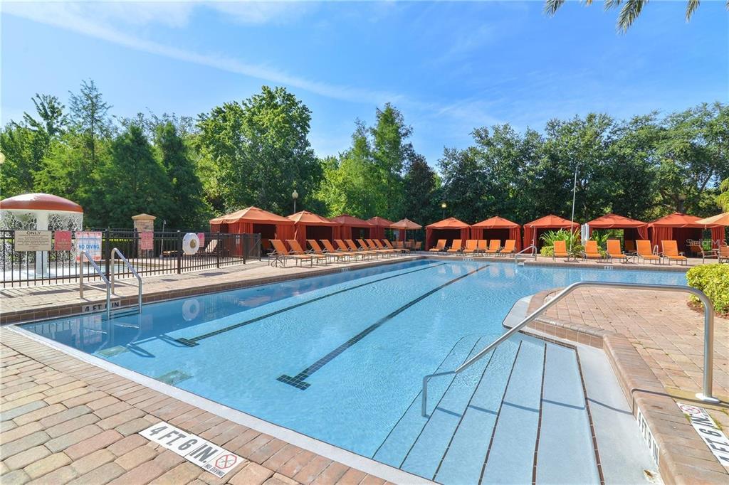 An outdoor swimming pool with a mushroom fountain and orange cabanas under a blue sky — 8010 TUSCANY WAY UNIT 5105, DAVENPORT, FL