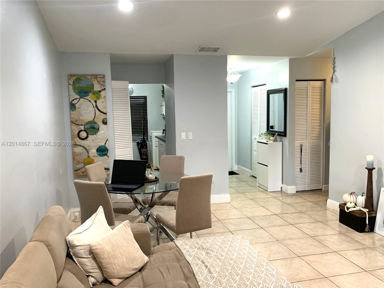 A living and dining area features tile flooring, a glass table, and light-colored walls — 4904 SW 139th Ct, Miami FL 33175, MIAMI, FL