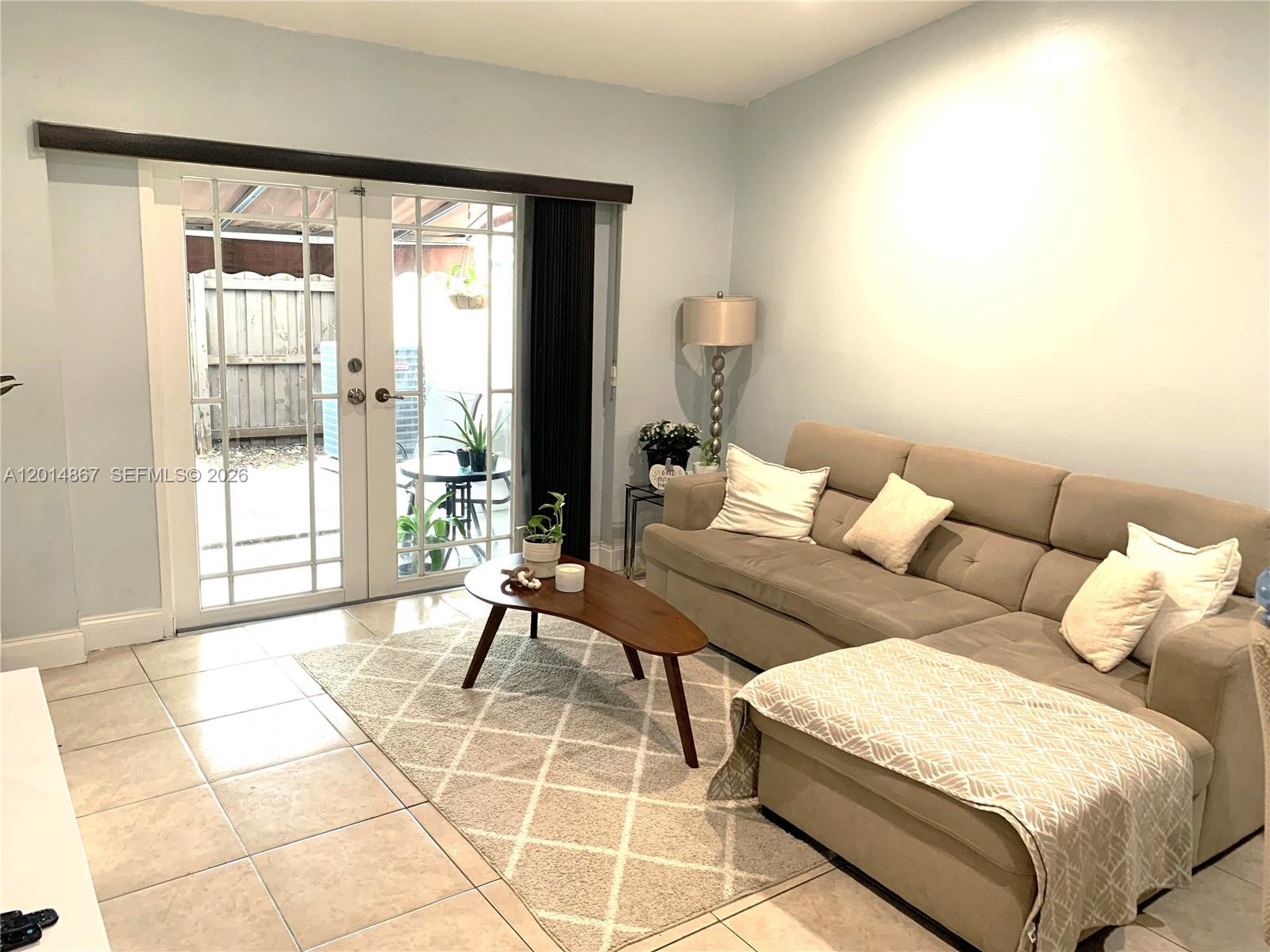 A living room features a beige sectional sofa, a coffee table, and glass patio doors — 4904 SW 139th Ct, Miami FL 33175, MIAMI, FL