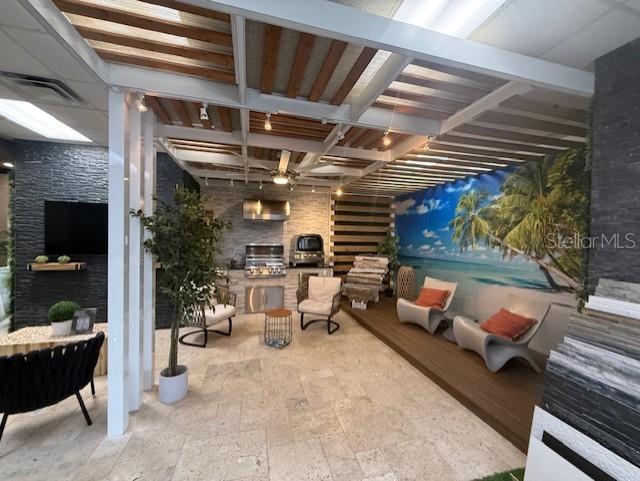 This showroom features a covered outdoor living area with stone walls, a grill, and seating — 3852 L B MCLEOD ROAD, ORLANDO, FL