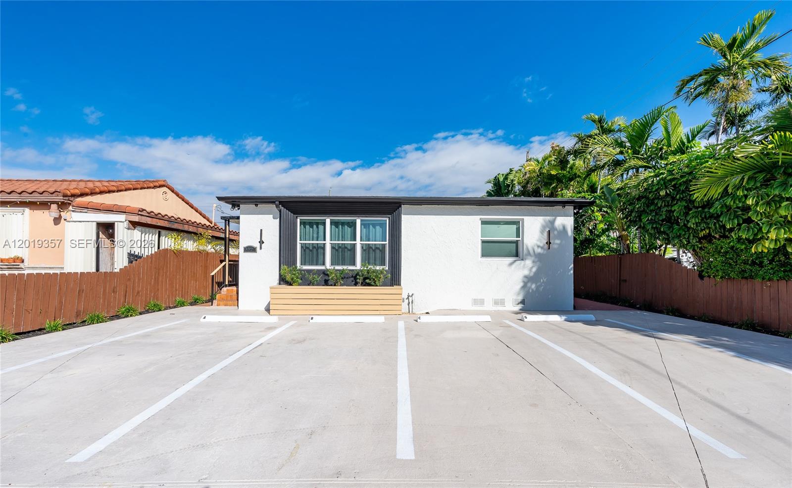 A white single-story building features a large front window and four marked parking spaces — 3321 NW 19th Ter, Miami FL 33125, MIAMI, FL