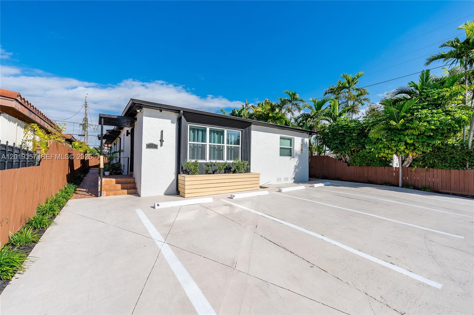 A white single-story building features a paved parking lot with marked spaces in front — 3321 NW 19th Ter, Miami FL 33125, MIAMI, FL
