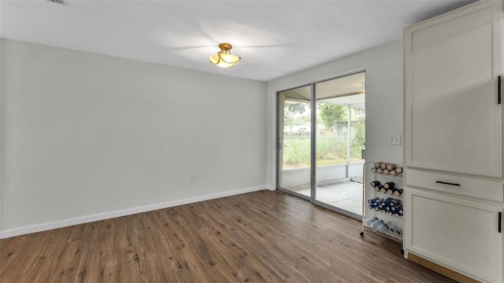 A dining area features wood-look flooring, a ceiling light, and sliding glass doors to a patio — 217 4TH JPV STREET, WINTER HAVEN, FL