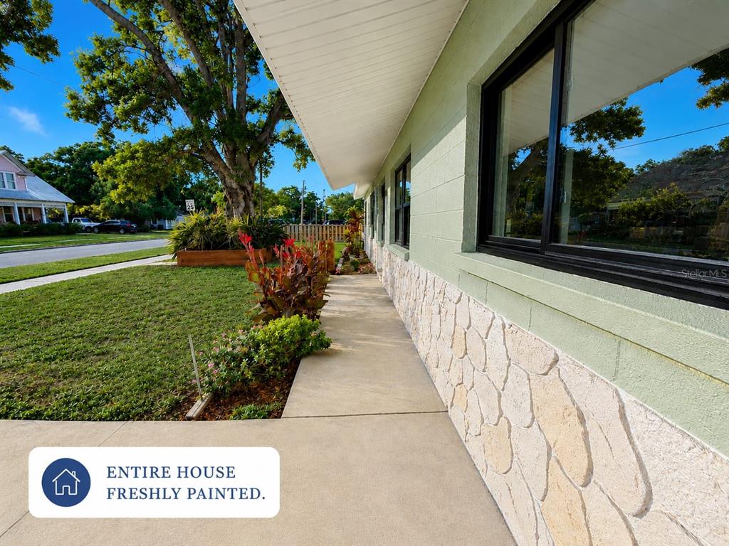 A black front door with four glass panels and a bee decoration on a house — 7001 59TH STREET N, PINELLAS PARK, FL