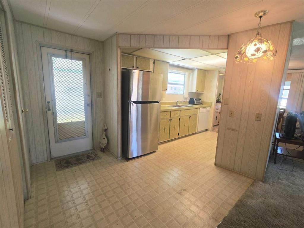 A kitchen with light-colored cabinets, a stainless steel refrigerator, and a linoleum floor — 39820 US HIGHWAY 19 N UNIT 182, TARPON SPRINGS, FL