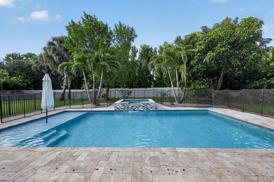 A swimming pool with an attached spa and a patio area in a fenced backyard — 7050 Limestone Cay Road, FL 33458, FL