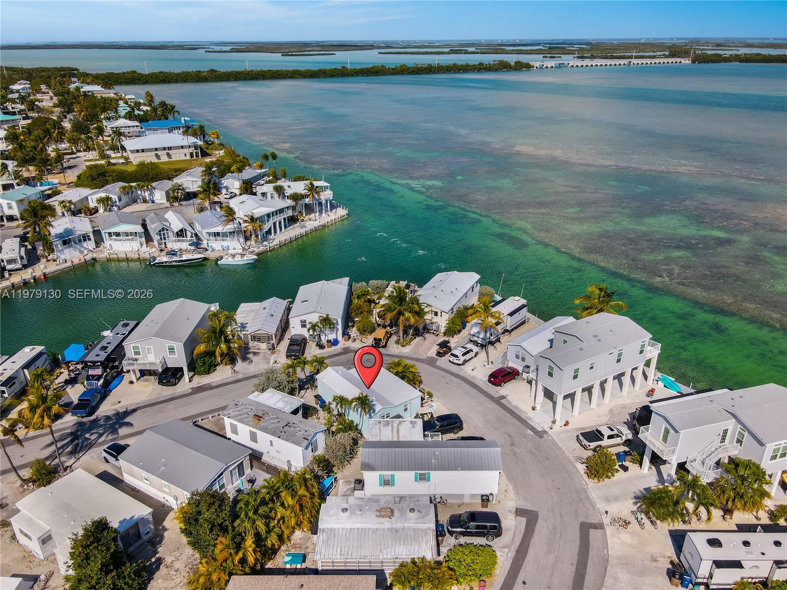 An aerial view shows a coastal neighborhood with houses situated near turquoise water — 701 Spanish Main Dr # 536, Lower Keys FL 33042, LOWER KEYS, FL