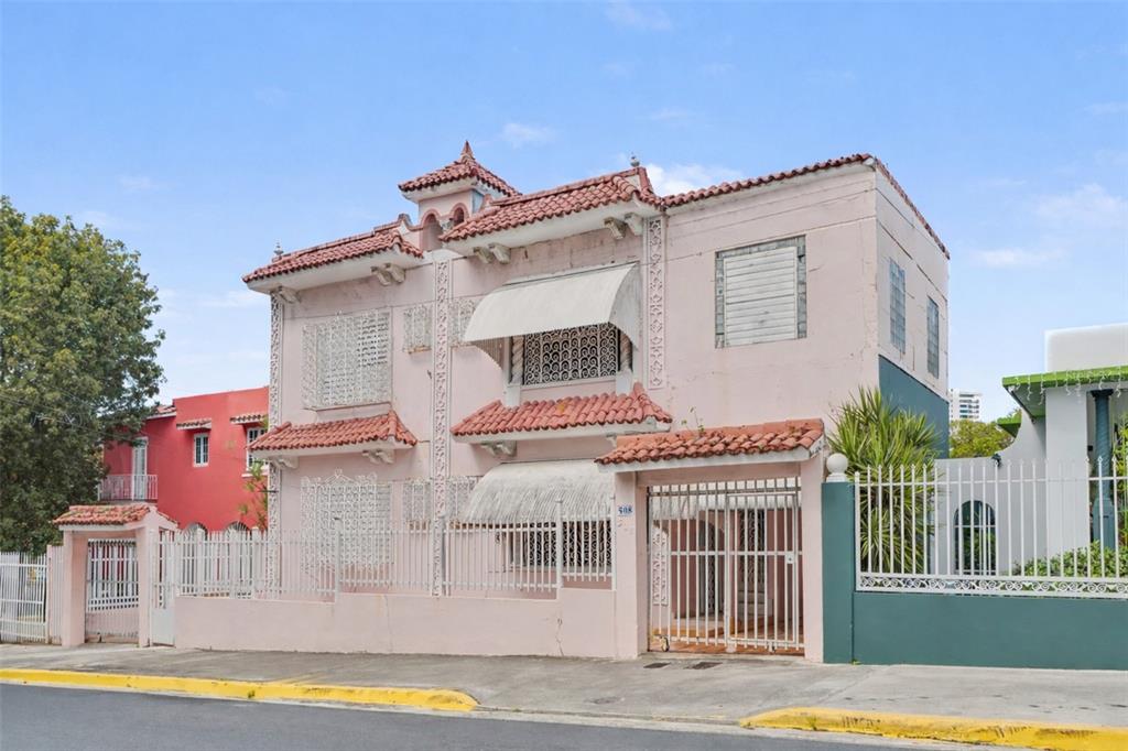 A two-story pink stucco house with a red tile roof and metal security grilles — 508 AVE. SAGRADO CORAZON AVENUE, SAN JUAN, PR