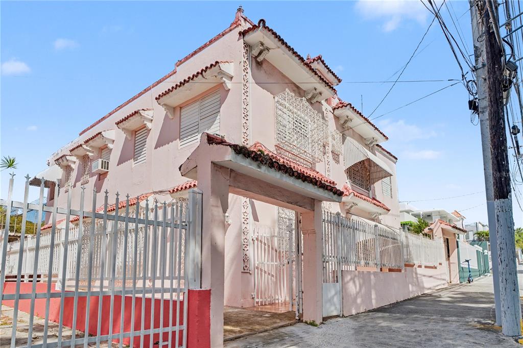 A pink two-story house with decorative metal grilles and a gated entrance on a street — 508 AVE. SAGRADO CORAZON AVENUE, SAN JUAN, PR