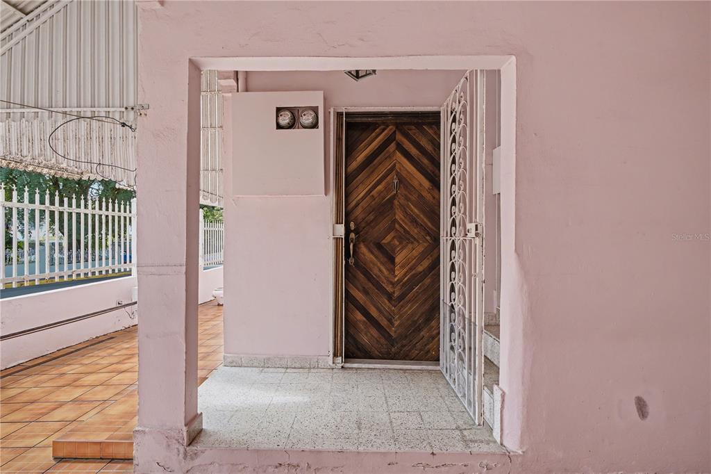A wooden front door with a metal security gate sits on a tiled porch — 508 AVE. SAGRADO CORAZON AVENUE, SAN JUAN, PR