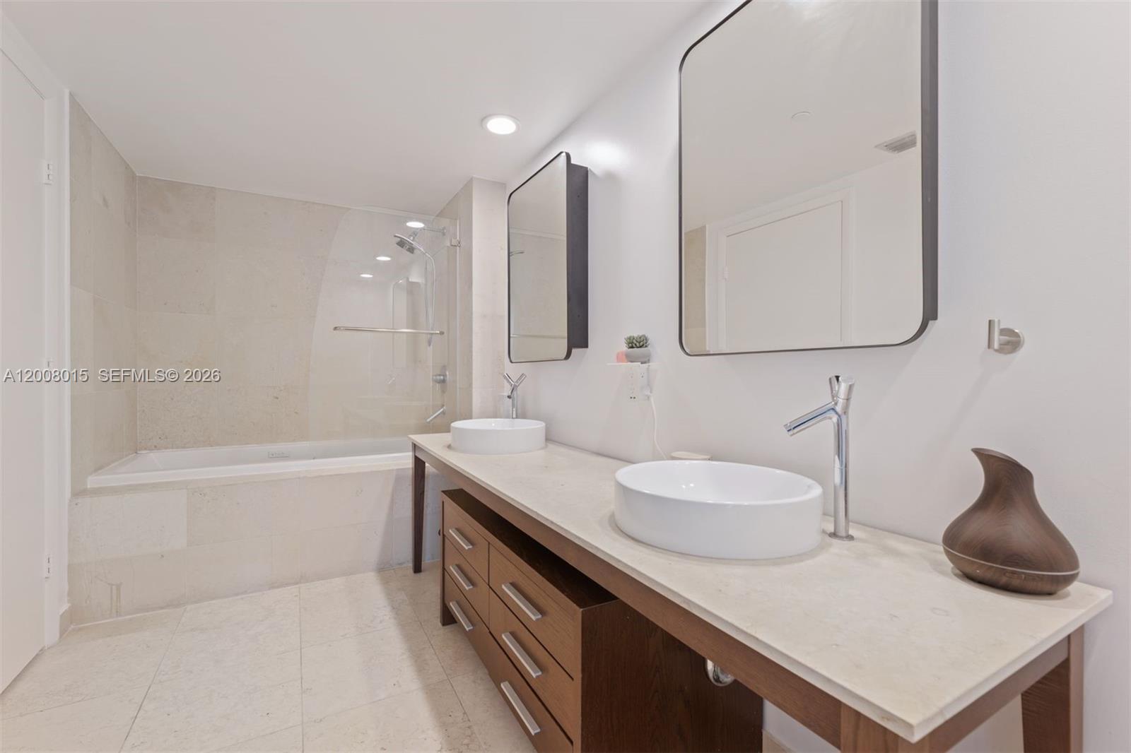 A modern bathroom features a double vanity with vessel sinks, wood cabinetry, and a bathtub — 495 Brickell Ave # 3509, Miami FL 33131, MIAMI, FL