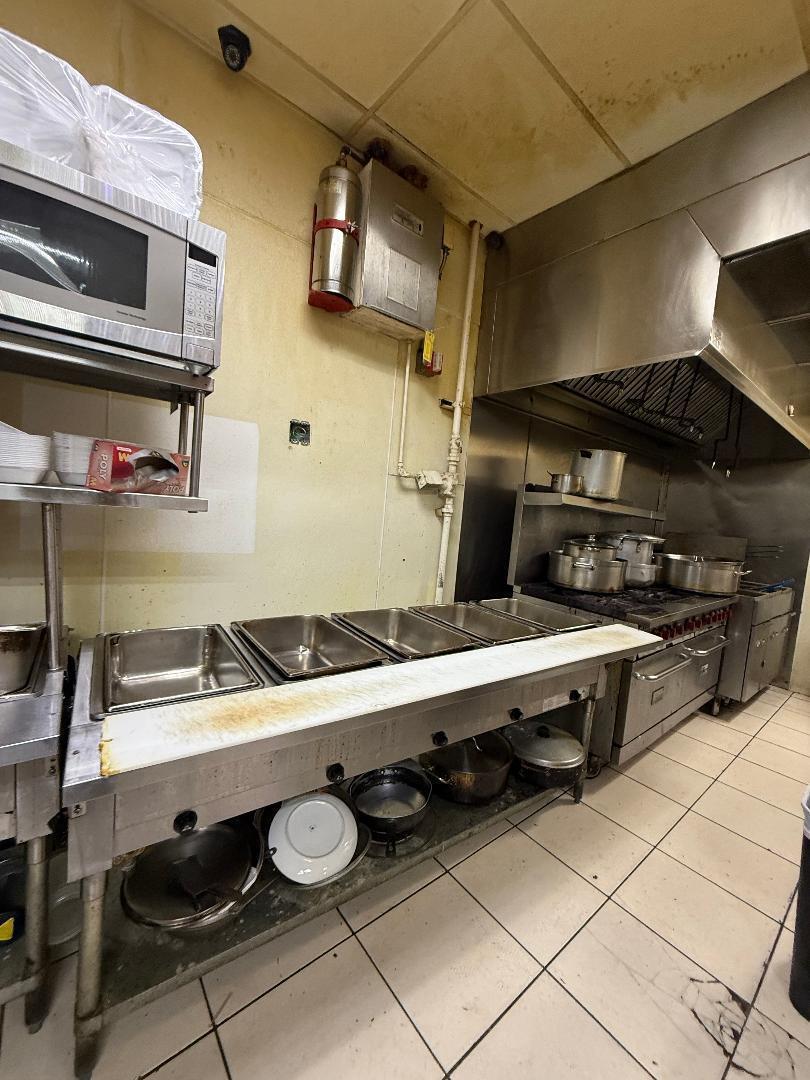 A commercial kitchen featuring stainless steel prep tables, a stove, and a ventilation hood — 9999 W Blue Heron Boulevard, Riviera Beach FL 33404, RIVIERA BEACH, FL