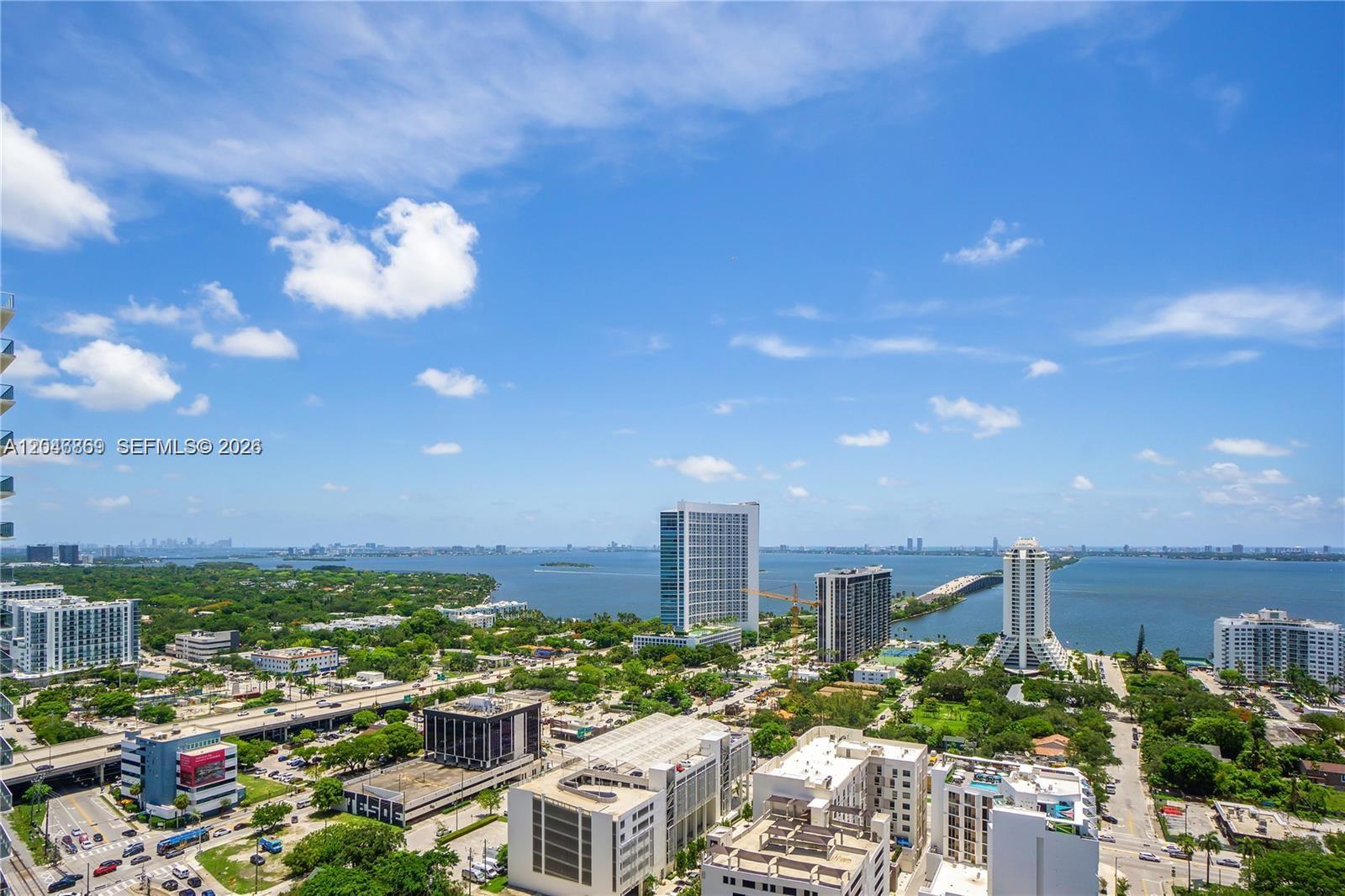 An elevated view shows a city skyline, a bridge, and a large body of water — 121 NE 34th St # 2706, Miami FL 33137, MIAMI, FL