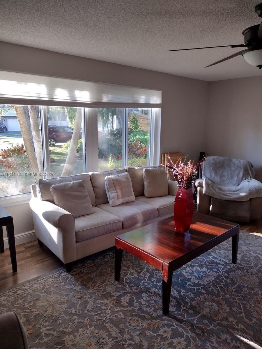 A living room features a beige sofa, a dark wood coffee table, and large windows — 14531 Hickory Ct, Davie FL 33325, DAVIE, FL