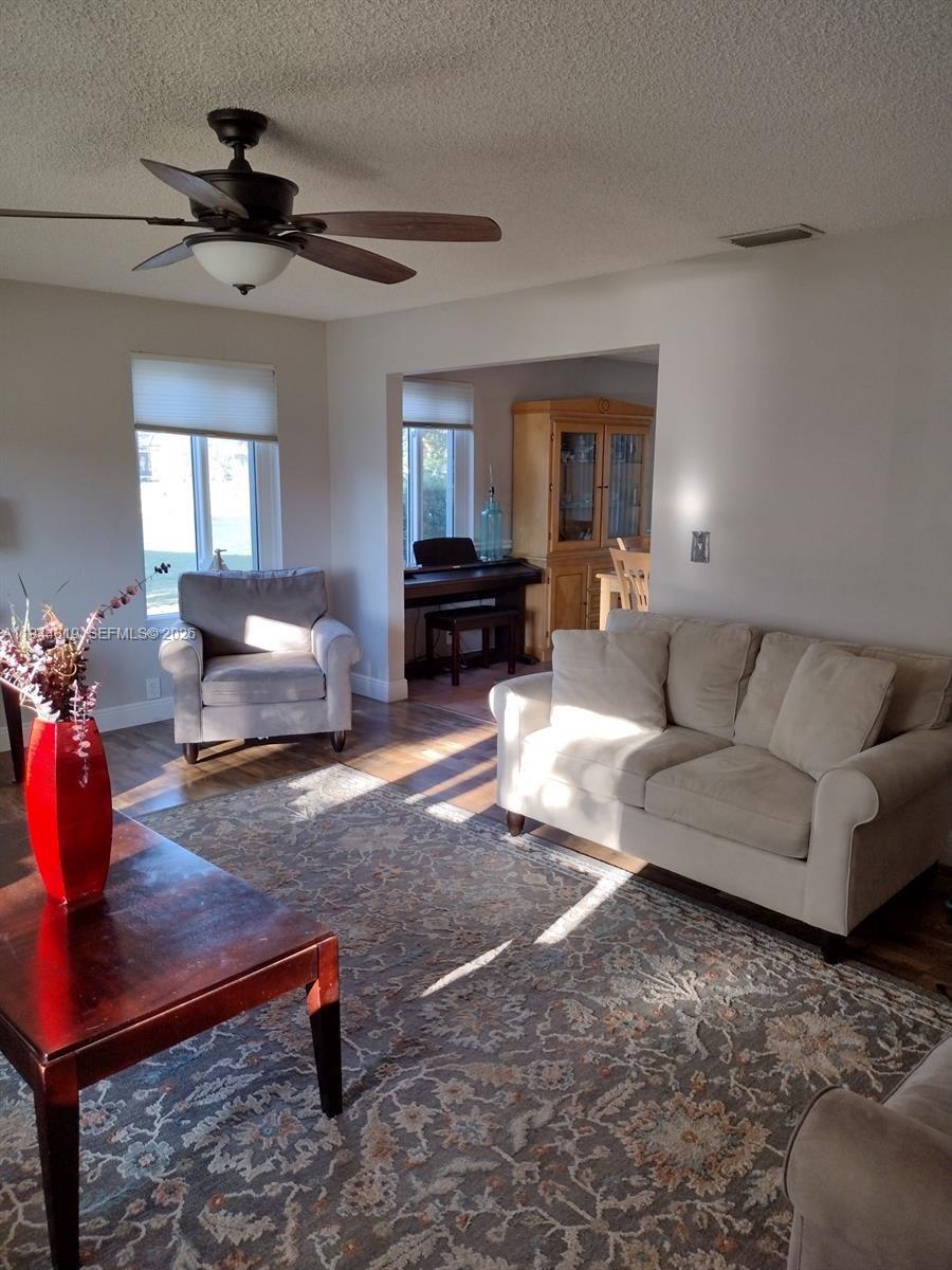 A living room features a beige sofa, a gray armchair, and a dark wood coffee table — 14531 Hickory Ct, Davie FL 33325, DAVIE, FL