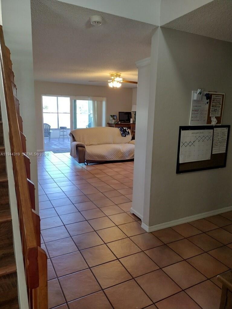 A tiled living area features a sofa, a ceiling fan, and a sliding glass door — 14531 Hickory Ct, Davie FL 33325, DAVIE, FL
