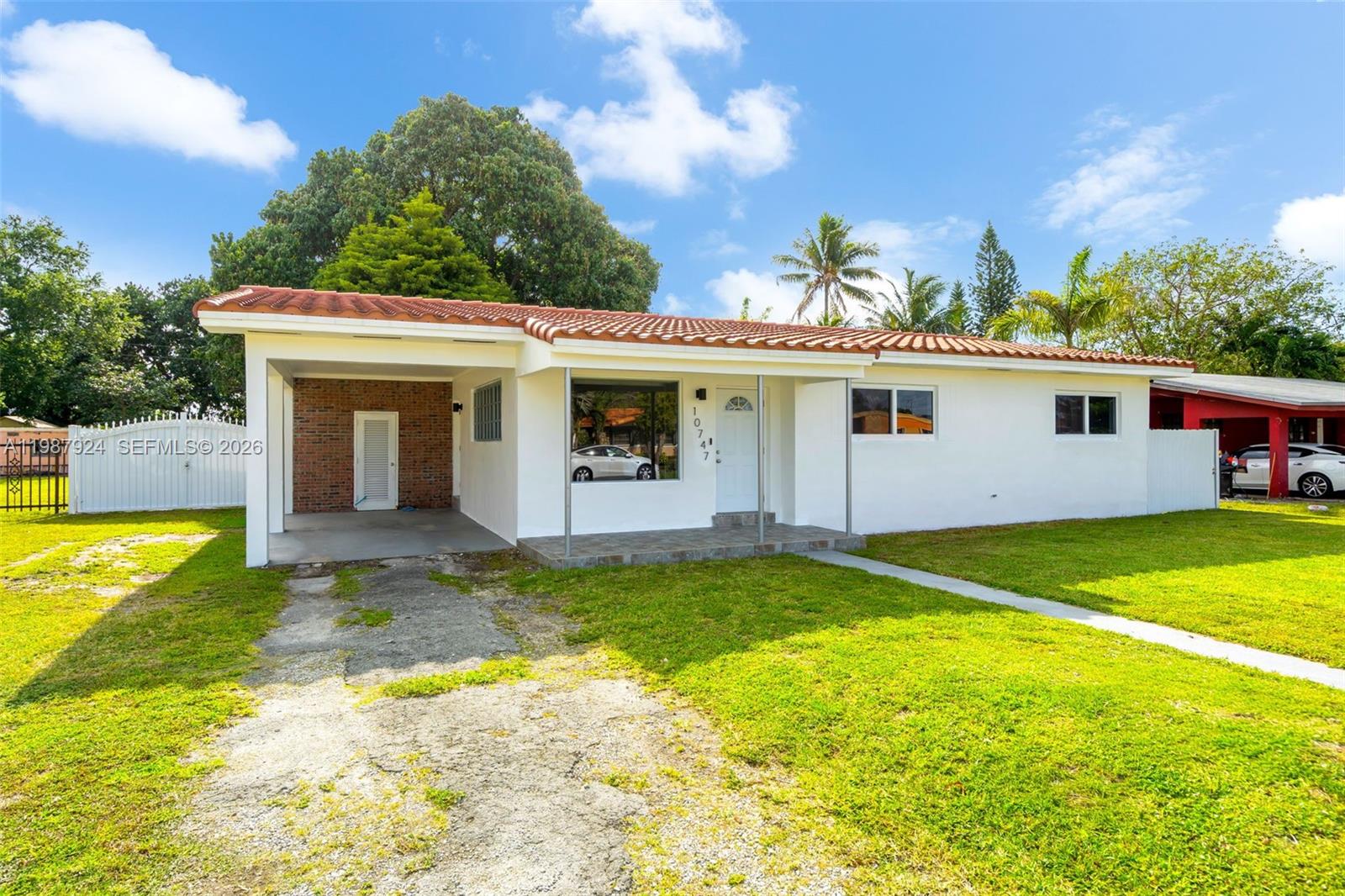 A single-story white house with a red tile roof and a front carport — 10747 NW 22nd Ct, Miami FL 33167, MIAMI, FL