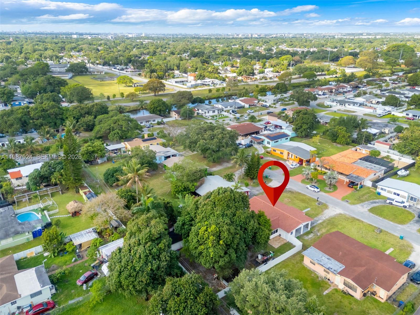 An aerial view shows a residential neighborhood with a red-roofed house marked by a pin — 10747 NW 22nd Ct, Miami FL 33167, MIAMI, FL