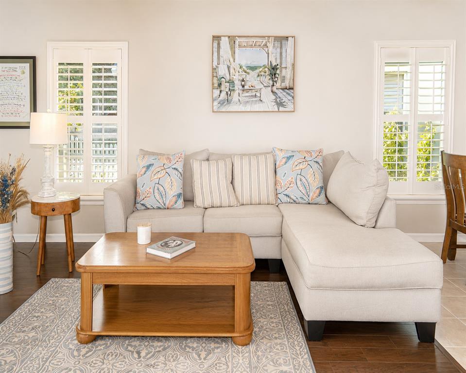 A living room features a beige sectional sofa, a wooden coffee table, and plantation shutters — 10839 NEWBRIDGE DRIVE, RIVERVIEW, FL