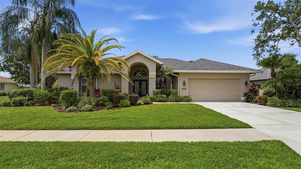 A screened-in swimming pool with a white handrail sits on a concrete patio — 7117 DORNOUGH LANE, BRADENTON, FL