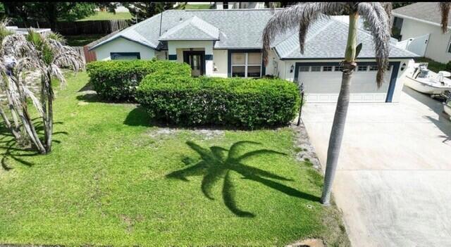 A single-story house with a manicured hedge, a palm tree, and a driveway — 726 Tuxedo Terrace, Sebastian FL 32958, SEBASTIAN, FL