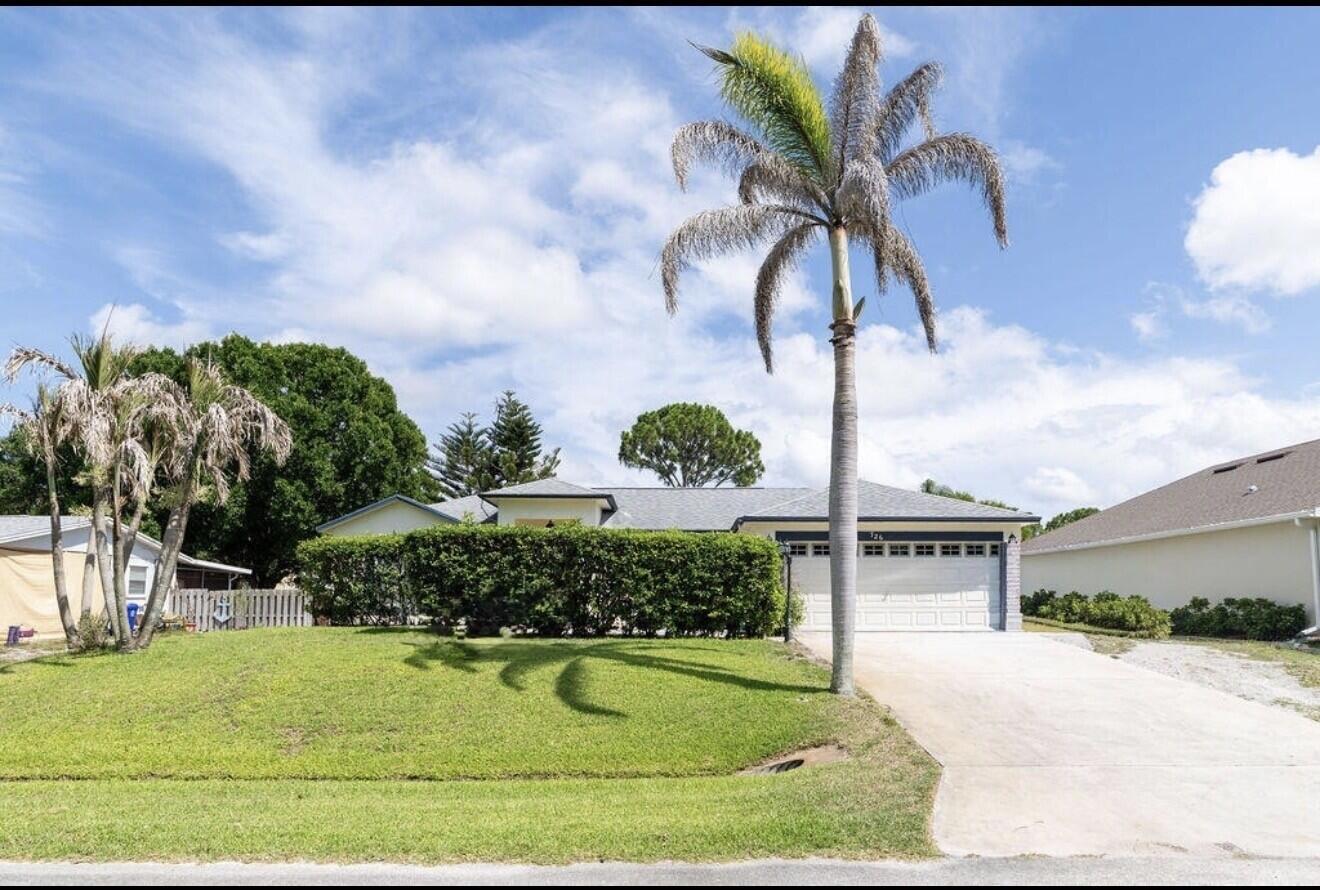A single-story house with a large palm tree, a manicured hedge, and a concrete driveway — 726 Tuxedo Terrace, Sebastian FL 32958, SEBASTIAN, FL