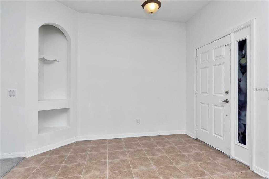 An entryway with tiled flooring, white walls, a recessed arched niche, and a front door — 29822 BOYETTE OAKS PLACE, WESLEY CHAPEL, FL