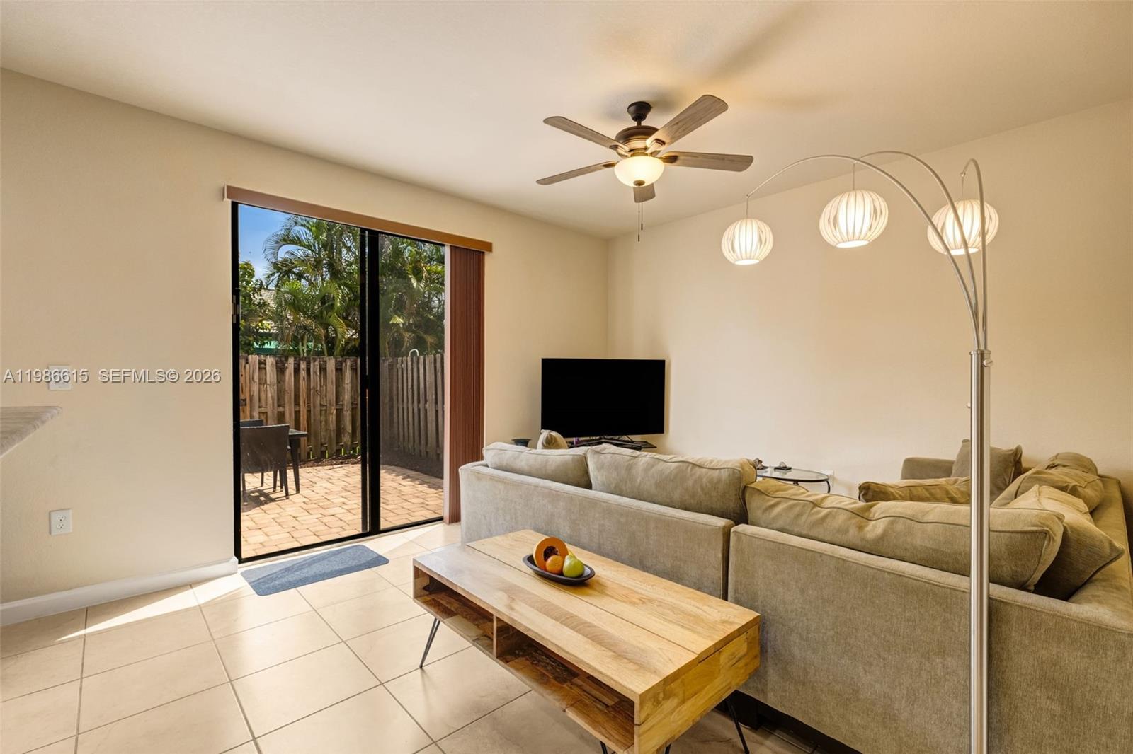 A living room features a beige sectional sofa, wood coffee table, and sliding glass patio doors — 4233 SW 164th Ct, Miami FL 33185, MIAMI, FL