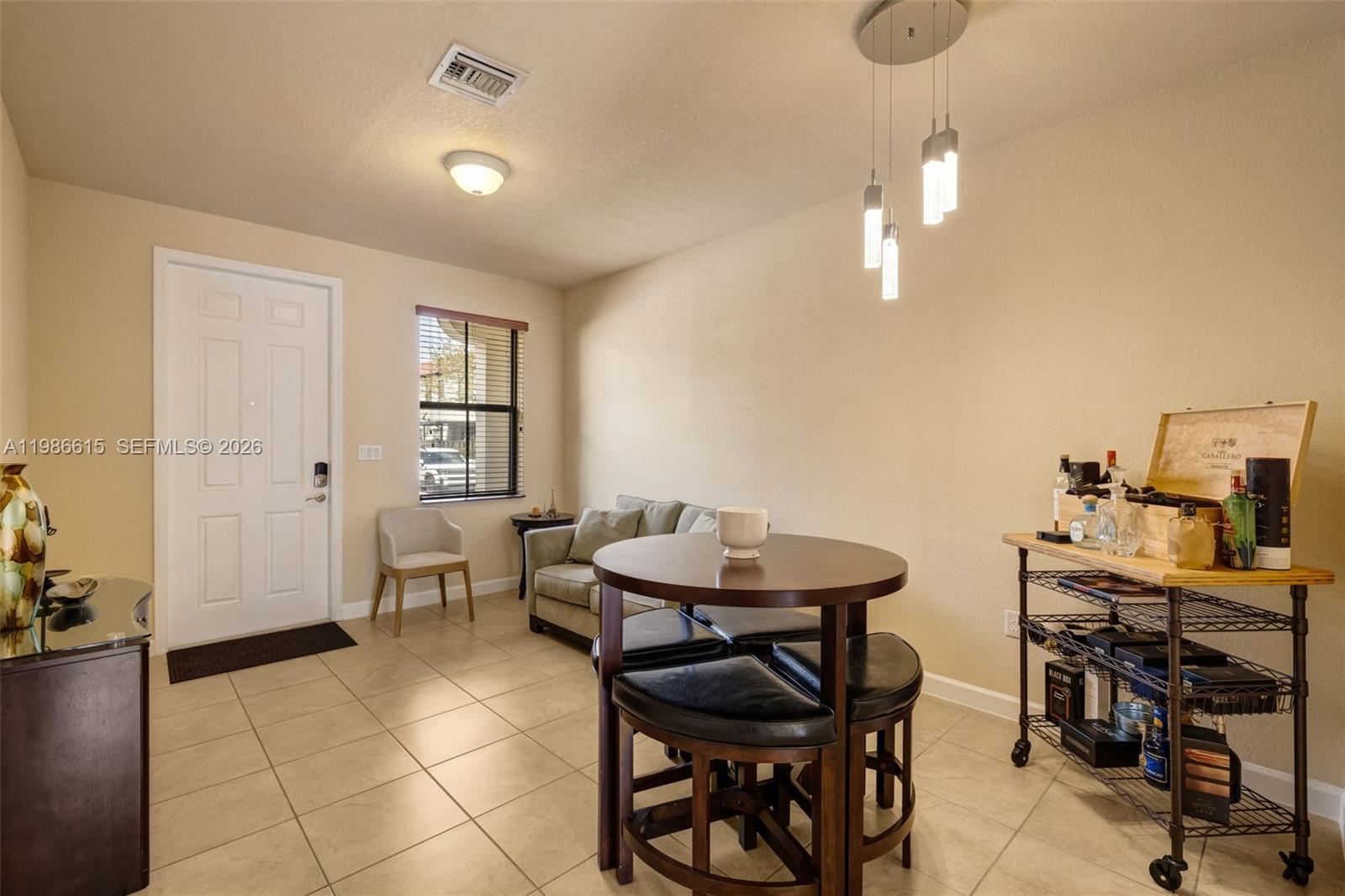 A dining area features a round table with stools, a bar cart, and a small sofa — 4233 SW 164th Ct, Miami FL 33185, MIAMI, FL