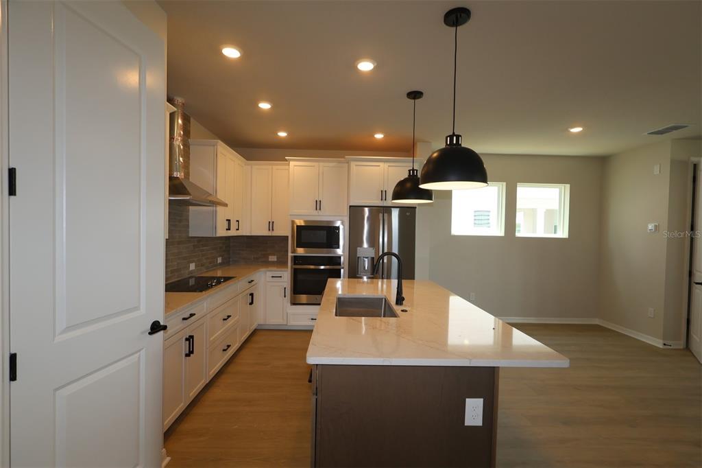 An empty room with light wood-look flooring, recessed lighting, and a large window wall — 6737 FOUNTAIN GROVE PASS, ST CLOUD, FL
