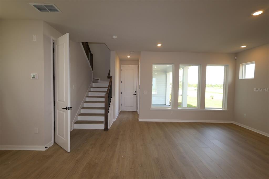A modern kitchen features white upper cabinets, a large island with a sink, and stainless appliances — 6737 FOUNTAIN GROVE PASS, ST CLOUD, FL