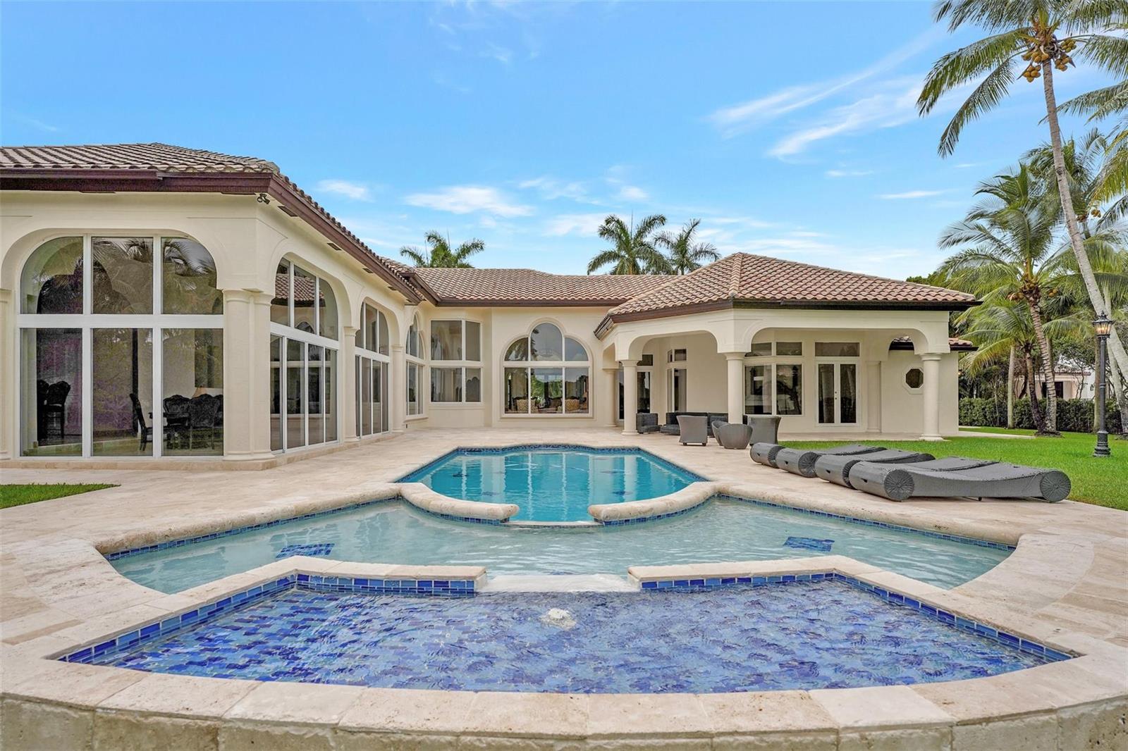 A backyard features a swimming pool with a spa and a patio beside a house — 3440 Stallion Lane, Weston FL 33331, WESTON, FL