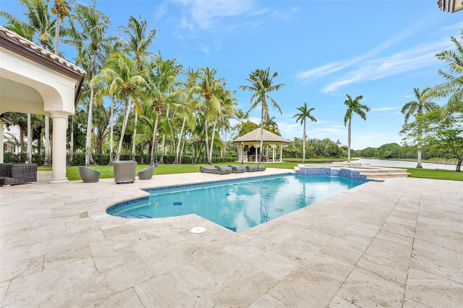 A swimming pool with a spa and patio sits in a backyard with palm trees — 3440 Stallion Lane, Weston FL 33331, WESTON, FL