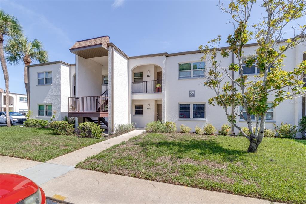 A two-story apartment building with stucco walls, a covered entryway, and a small balcony — 7701 STARKEY ROAD UNIT 528, SEMINOLE, FL