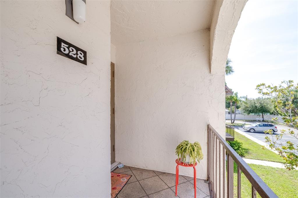 A covered balcony with a tiled floor, a metal railing, and a potted plant — 7701 STARKEY ROAD UNIT 528, SEMINOLE, FL