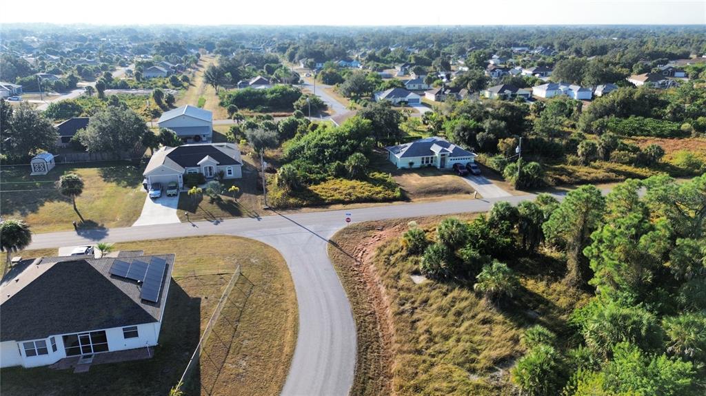 An aerial view shows several suburban houses surrounded by trees and grassy lots — LOT 25, LEOPOLD AVENUE, NORTH PORT, FL